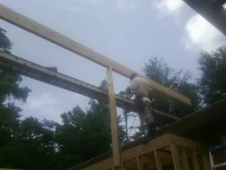 Carpenter setting a ridge beam over a new addition frame — Ice Dam Removal by Roofing Brothers in Dateland