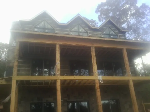 Dormers and porch framing on a large log home under construction — Roof Coating work by our crew in Dateland