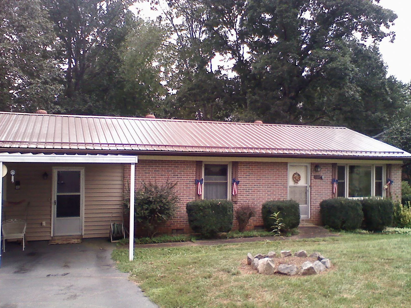 Bronze metal roof and carport on a brick ranch home — Roof Repair work by our crew in Dateland